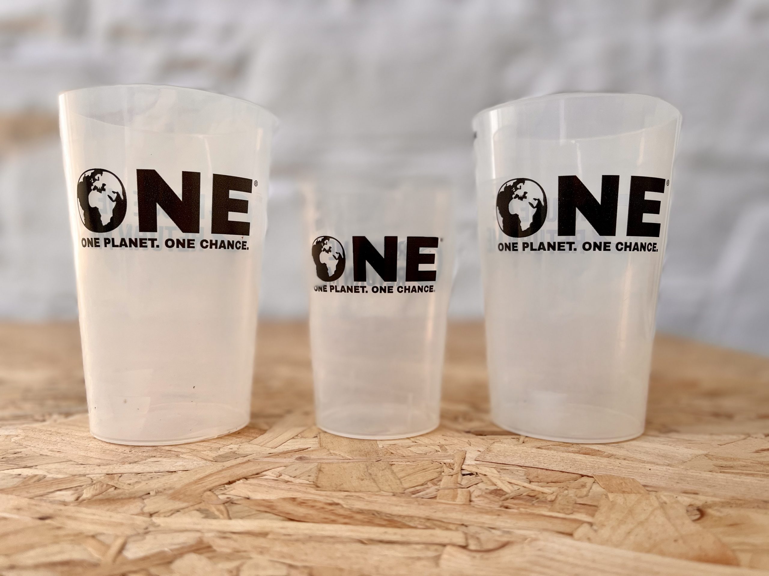 Three reusable cups with 'One Planet, One Chance' logo 